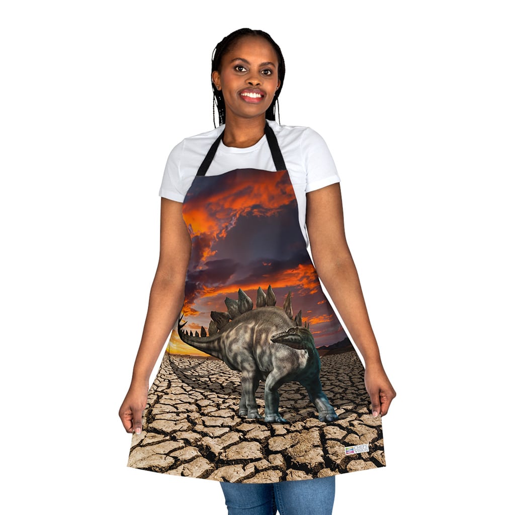 A woman wearing a Chef's Vision Jurassic Apron in the desert, perfect for dinosaur enthusiasts looking for a unique gift.