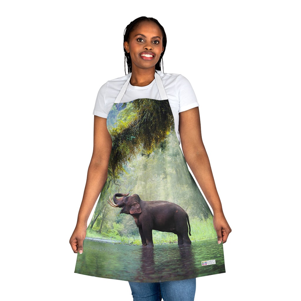 A woman wearing a Chef's Vision Wildlife Apron with an elephant in the water.