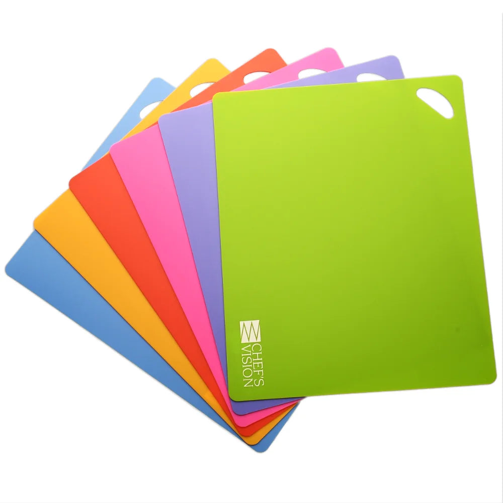 A set of six SliceBright Flexible Cutting Mats by Chef's Vision is fanned out and stacked, each featuring a convenient handle cutout in the corner. These color-coded boards are dishwasher safe, with the green mat at the front displaying the "Chef's Vision" logo.