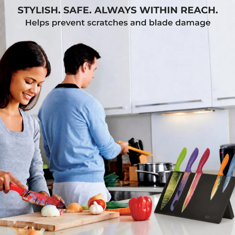 A woman chops vegetables as a man cooks in a modern kitchen; the Chef's Vision BEHOLD Magnetic Kitchen Knife Block sits on the counter, highlighted by text about knife safety, stylish design, and smart organization.