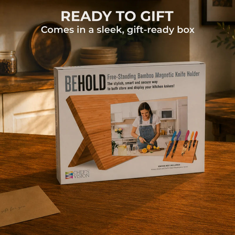 The BEHOLD Magnetic Kitchen Knife Block by Chef's Vision is shown in a sleek, gift-ready box on a wooden table. A small envelope accompanies it, making this elegant knife organizer perfect for stylish kitchen storage.