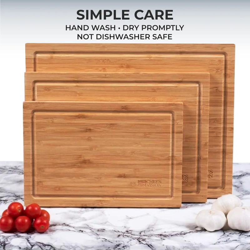 Three SliceBright Moso Bamboo Cutting Boards by Chef's Vision are displayed in varying sizes on a marble surface alongside cherry tomatoes and garlic. Designed with knife-friendly surfaces and deep juice grooves, these boards make food prep simple while safeguarding your countertops. Care instructions above advise: hand wash, dry promptly, not dishwasher safe.