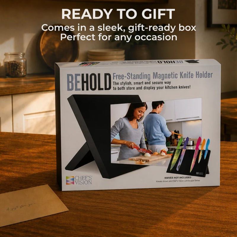 A boxed BEHOLD Magnetic Kitchen Knife Block by Chef's Vision sits on a wooden table beside an envelope, with promotional text above emphasizing effortless kitchen organization.