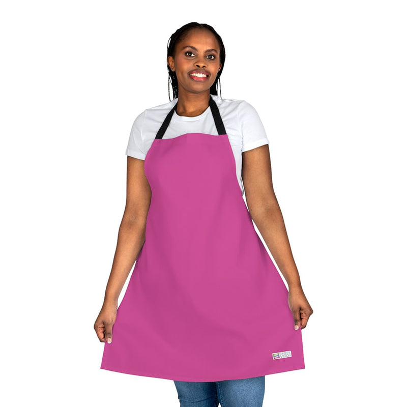 A woman wearing a vibrant pink Chef's Vision Color Apron.