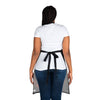 The back view of a woman wearing a Chef's Vision black Cosmos Apron in the kitchen.