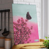 A pink butterfly on a pink flower graces a Chef's Vision SliceBright Wildlife Glass Cutting Board in a kitchen.