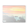 A SliceBright Landscape Glass Cutting Board from Chef's Vision, featuring a landscape themed picture of the ocean with rocks and a sunset, perfect for your kitchen.