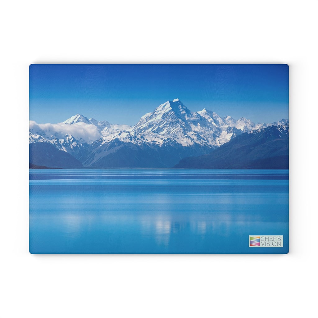 A stunning landscape of New Zealand's Mount Cook on a blue background, perfect for a kitchen decor with the Chef's Vision SliceBright Landscape Glass Cutting Board.