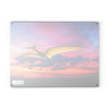 A white bird flying in the sky at sunset, soaring above the majestic dinosaurs of the Jurassic era on a SliceBright Jurassic Glass Cutting Board made by Chef's Vision.