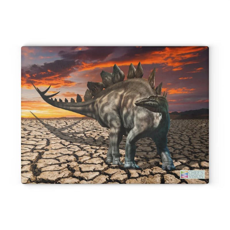 The Chef's Vision SliceBright Jurassic Glass Cutting Board features a stegosaurus on cracked ground beneath a sunset—dinosaur artwork that adds bold style to your kitchen counter.