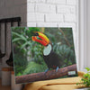 A toucan perched on a branch, with a Chef's Vision SliceBright Wildlife Glass Cutting Board displayed nearby.