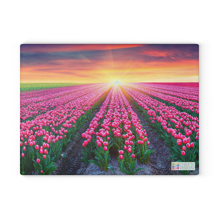 A field of pink tulips with the sun setting behind a Chef's Vision SliceBright Glass Cutting Board.