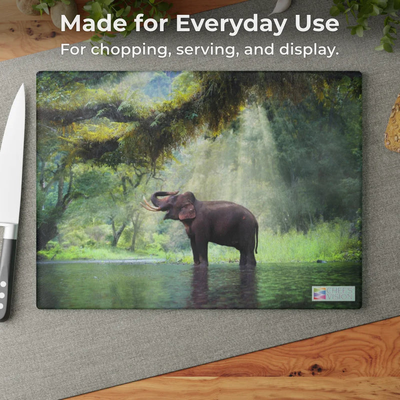 The Chef's Vision SliceBright Wildlife Glass Cutting Board showcases an elephant in a sunlit forest stream—functional art that brings beauty and utility to your kitchen, perfect for slicing bread or prepping on any countertop.