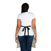 The back view of a woman wearing a white apron and a black belt, featuring a Chef's Vision Jurassic Apron perfect for dinosaur enthusiasts.