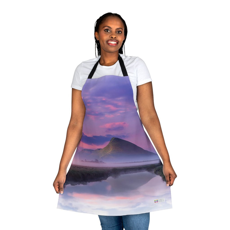 A woman wearing a Chef's Vision Landscape Apron with a mountain in the background.