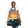 A woman wearing a Chef's Vision landscape apron on the beach during sunset.