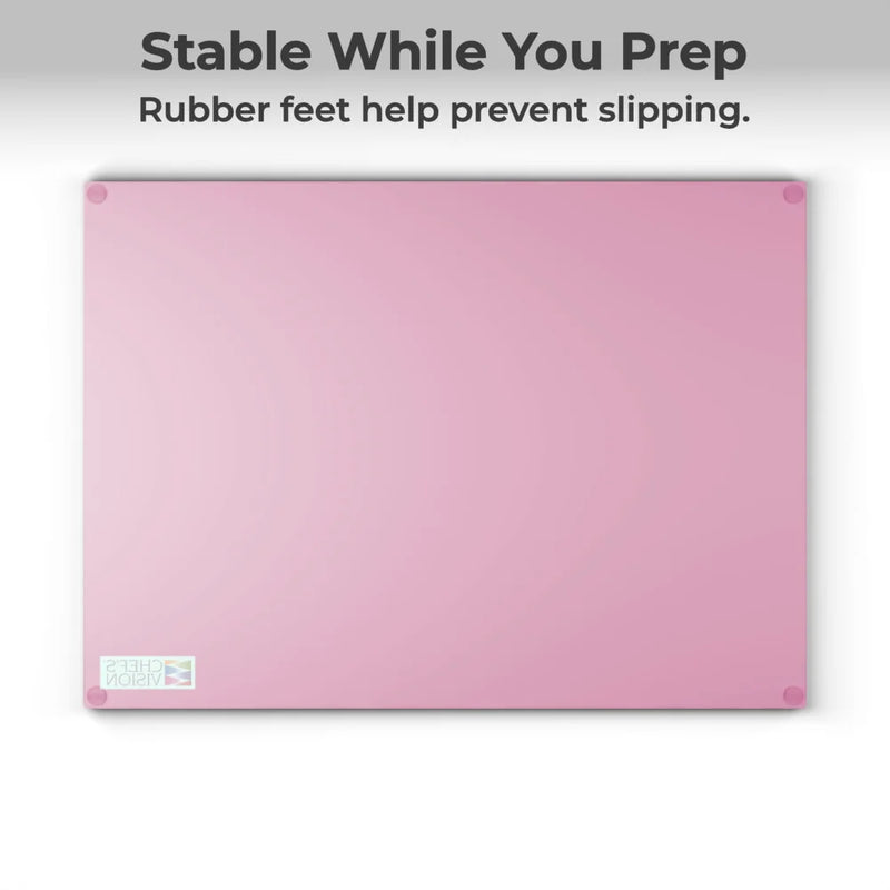 The Chef's Vision SliceBright Color Glass Cutting Board, shown in pink with rubber feet on each corner, sits beneath text: "Stable While You Prep. Rubber feet help prevent slipping on your kitchen counter.