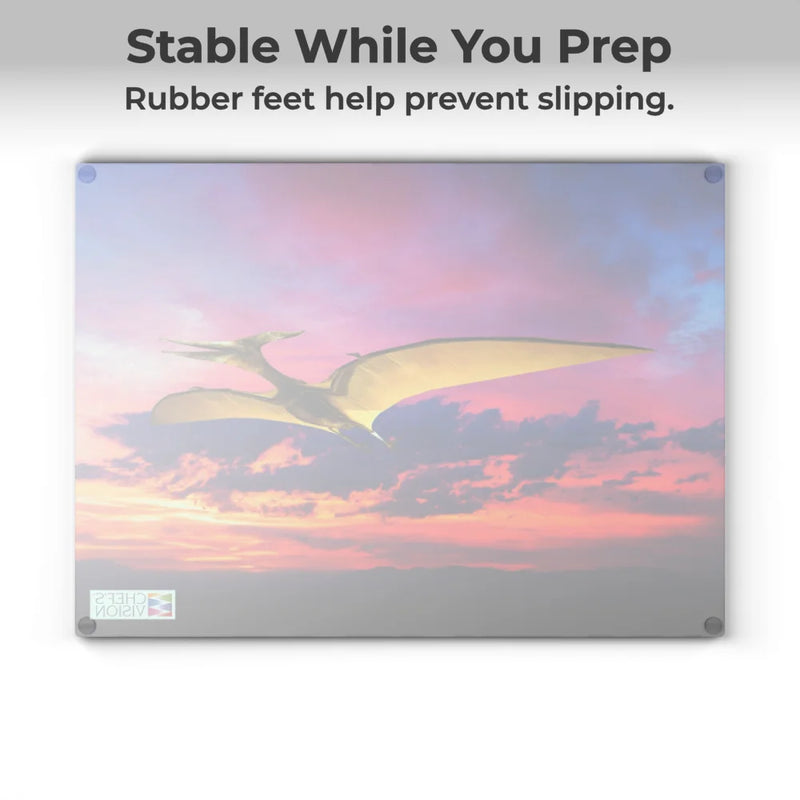 The Chef's Vision SliceBright Jurassic Glass Cutting Board showcases a vivid flying pterosaur at sunset, with tempered glass and rubber feet for stability on your kitchen counter.