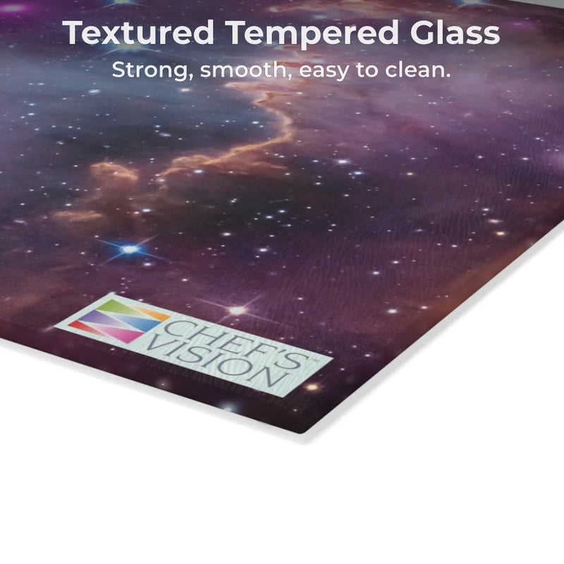 A corner of the SliceBright Cosmos Glass Cutting Board by Chef’s Vision, featuring cosmic art and logo; described as strong, smooth, and easy to clean—an ideal way to add style to your kitchen counter.