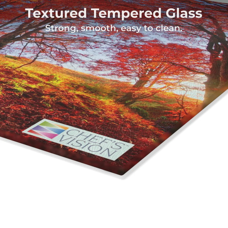 The Chef’s Vision SliceBright Landscape Glass Cutting Board features a textured, tempered glass surface with an autumn forest scene—strong, smooth, and easy to clean for any kitchen counter.