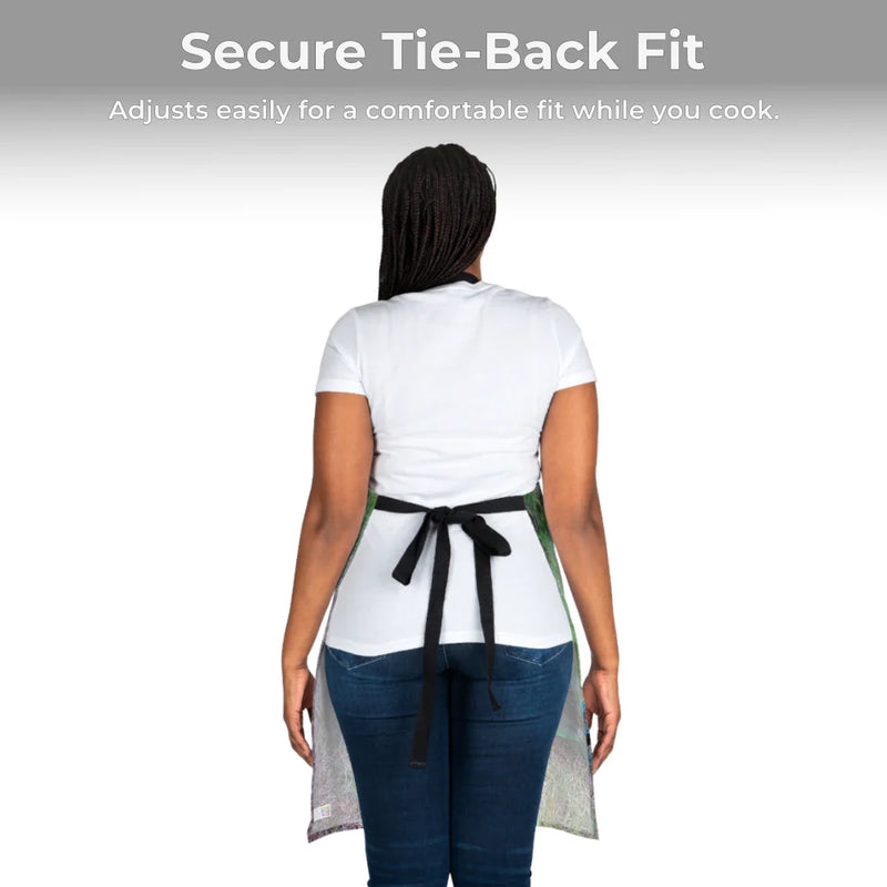 A person in a white shirt and jeans models the Chef's Vision Wildlife Apron from the back—a black, adjustable tie-back apron with animal-inspired artwork.